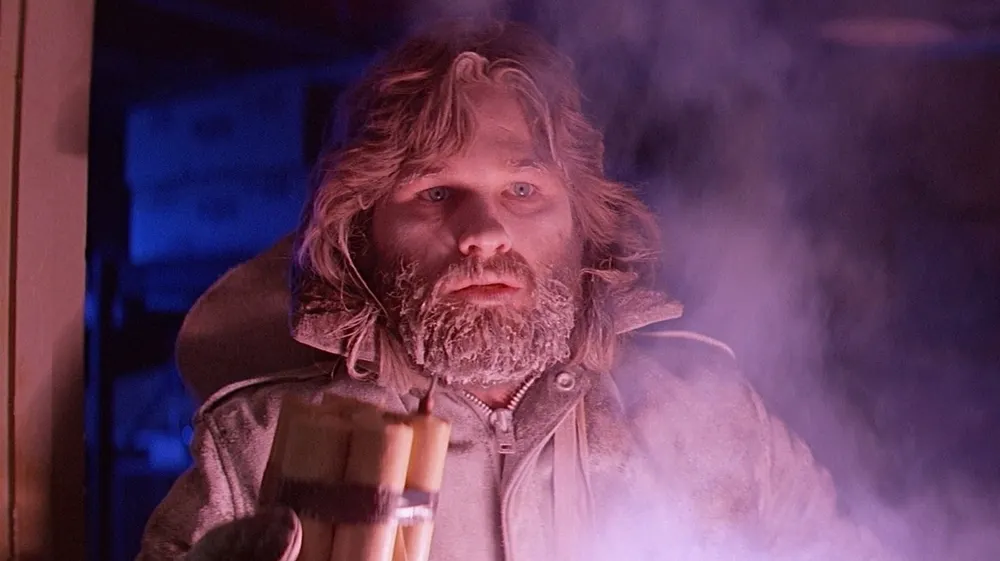 Kurt Russell como MacReady iluminado por una bengala en La cosa de John Carpenter